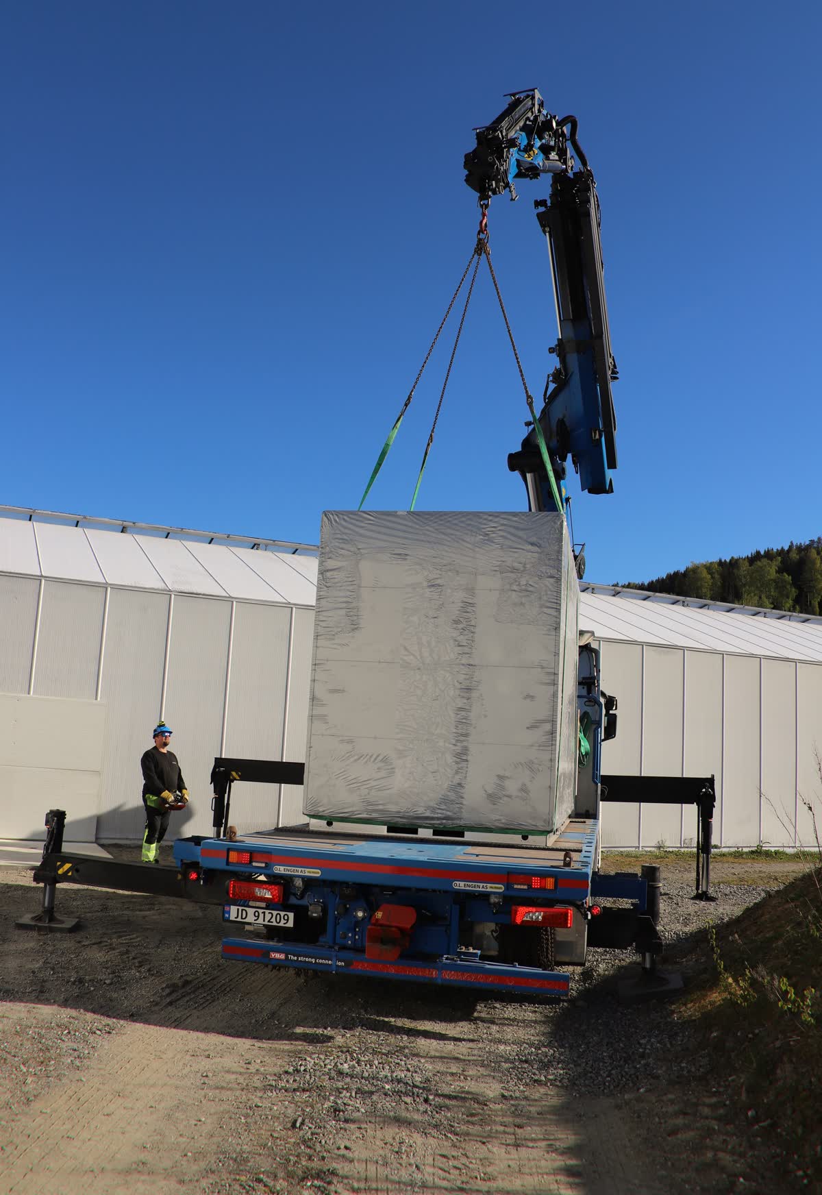 Kranarmen strukket mot blå himmel.